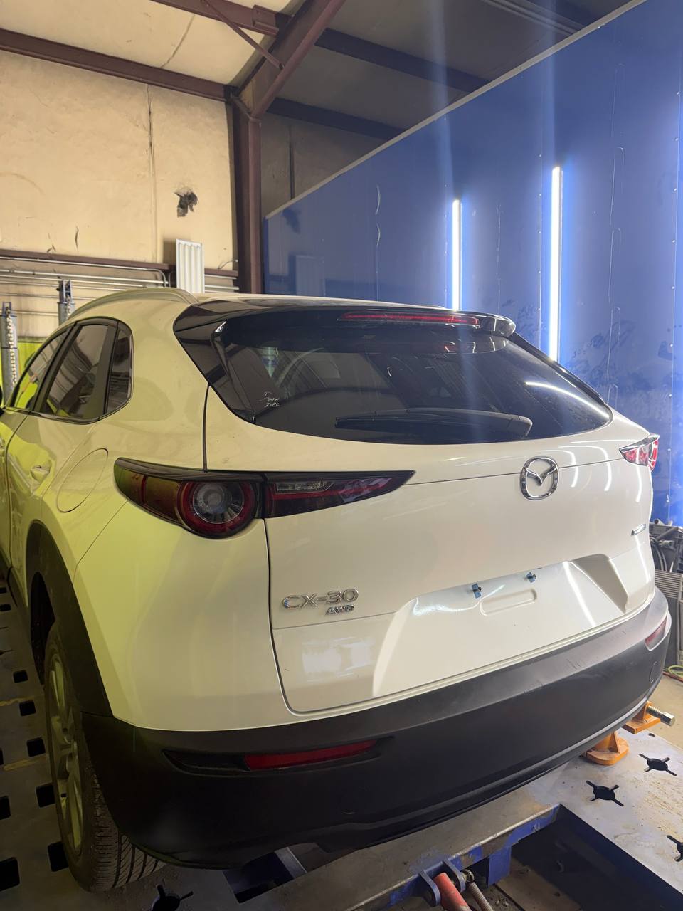 Orange Porsche Macan in for service at Prime Motors body shop Matthews NC